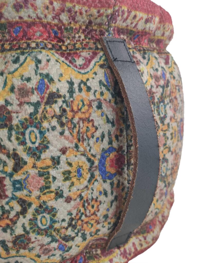 Close-up of leather handle on multi-color braided pouf with polyester and jute-thermocol filling