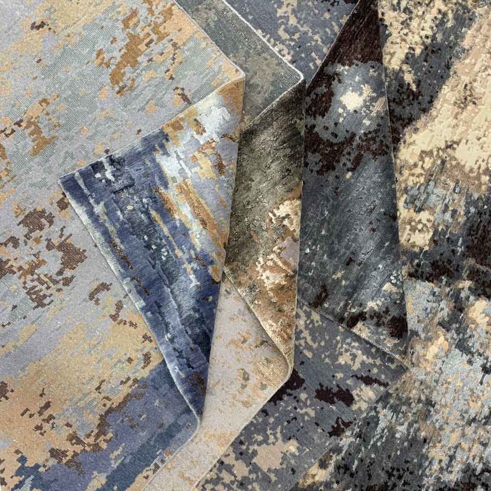 Hand knotted rugs half folded on top of each other showcasing texture and weave