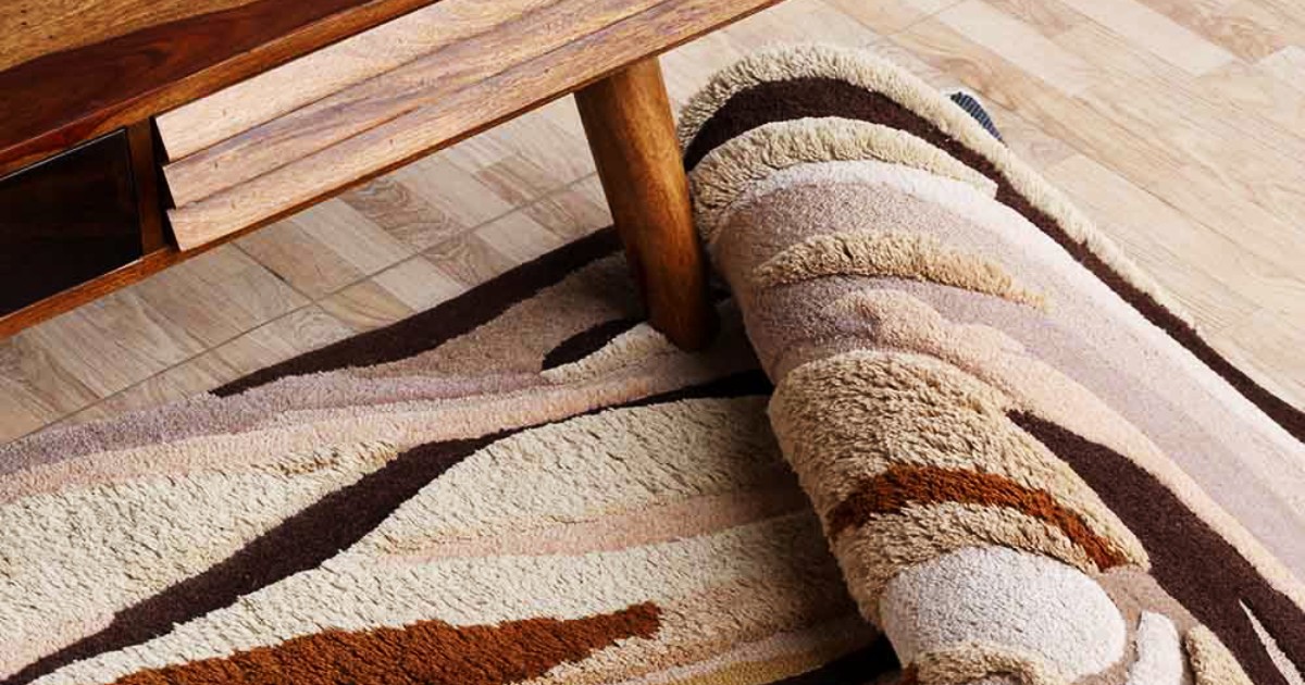 A professional technician fixing carpet ripples using a power stretcher in a luxury interior setting.