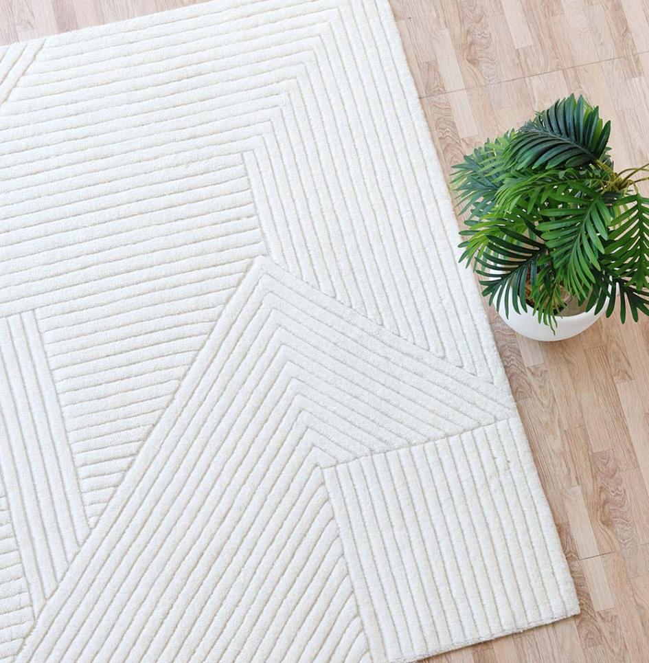 Overhead shot of a soft white shag rug made with New Zealand wool, styled with a decorative vase at the side
